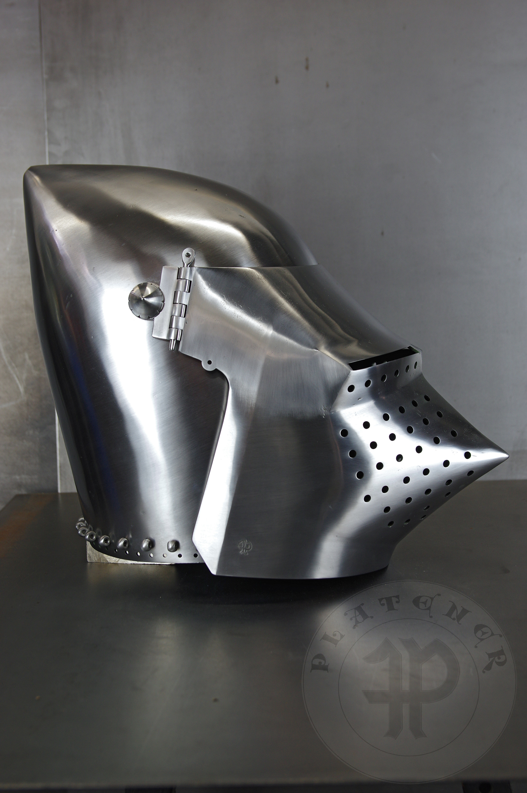 Visored bascinet based on example from Le Landeron in Switzerland, circa 1380-1400. Material: 2 mm steel with 0,3 % carbon. Heat treatment: hardened and tempered up to 34 HRC. Weight 4,090 kg / Przybica starszego typu tzw. psi pysk wzorowana na oryginale z Le Landeron w Szwajcarii, datowana na 1380-1400 rok. Materia: stal 2 mm o zawartoci wgla 0,3%. Hartowany i odpuszczany do 34 HRC. Waga 4,090 kg.